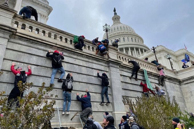 Trump supporters scale the west wall of the Capitol on January 6, 2021. 