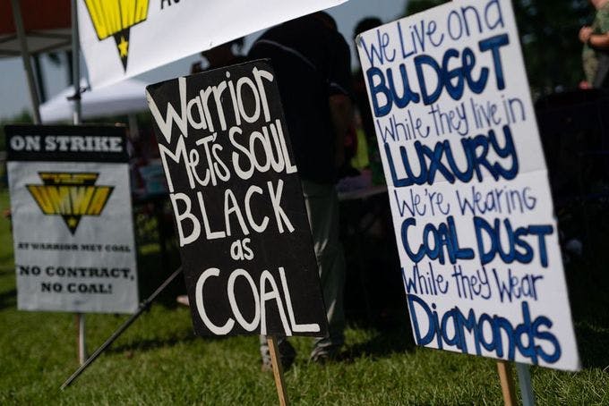 Yard signs including "Warrior Met's Soul Black as Coal" and "We live on a budget while they live in luxury we're wearing coal dust while they wear diamonds"