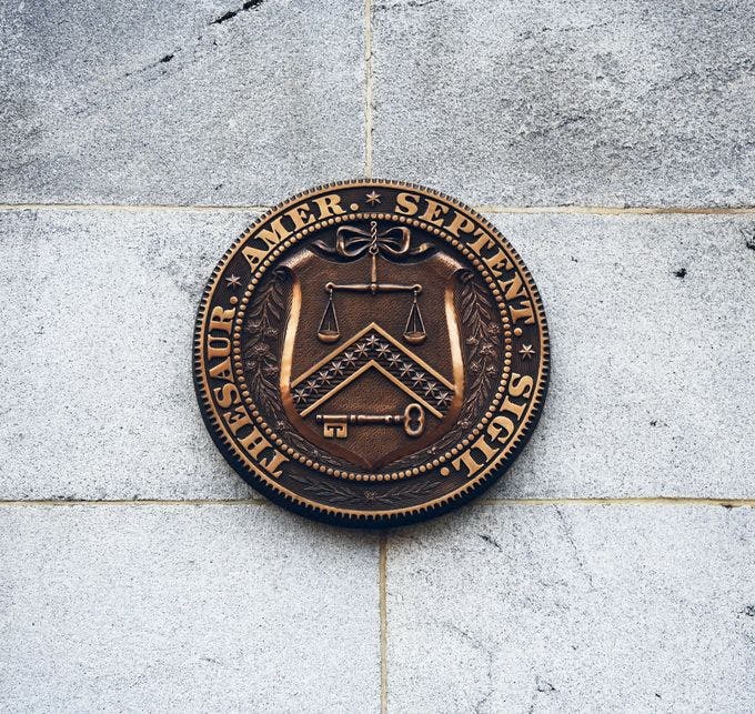 Picture of the seal of the U.S. treasury department on a stone building
