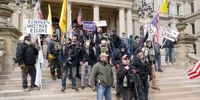 Rifle strapped protesters demand an end to the COVID lockdown on the steps of the Michigan capitol building